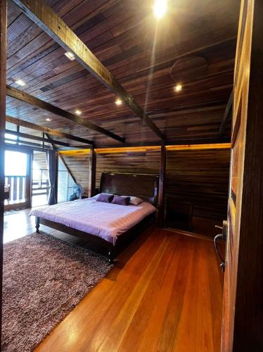 a large bed in a room with a wooden ceiling at SANKARA GARDEN in Pantai