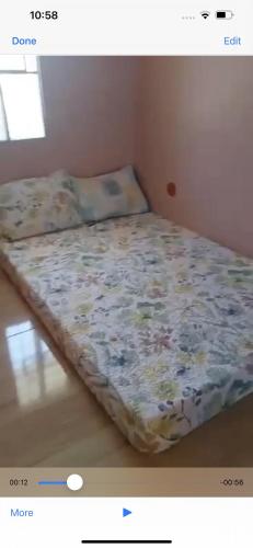 a bed with a floral comforter in a room at Rcd villas de bacoor in Dulong Bayan