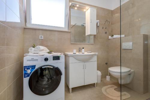 y baño con lavadora y aseo. en KAIROS, en Bilice