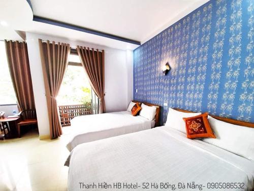 ein Schlafzimmer mit 2 Betten und einer blauen Wand in der Unterkunft Thanh Hiền HB Hotel in Đà Nẵng