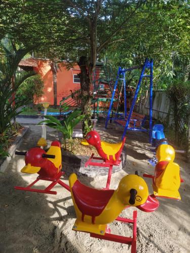 a playground with colorful chairs and a swing at The Lake Paradise Boutique Resort in Alleppey