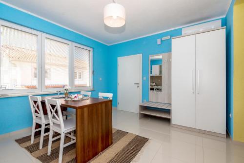a dining room with blue walls and a table and chairs at KAIROS in Bilice