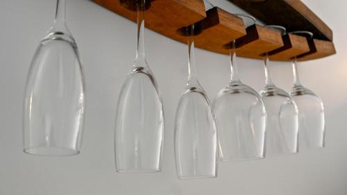 a group of wine glasses hanging from a wall at Modern and Private Guesthouse with Hot Tub located 500m to Havelock North Village in Havelock North