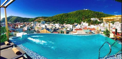 a large swimming pool with a city in the background at Milan Corner Hotel in Vung Tau