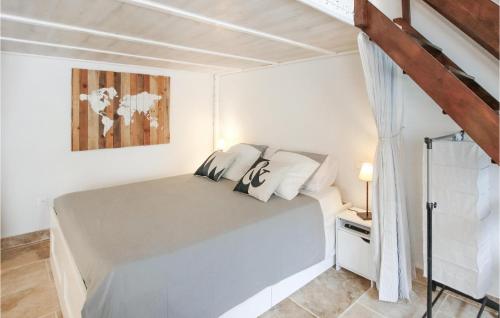 ein weißes Schlafzimmer mit einem Bett und einem Gemälde in der Unterkunft Beautiful Home In Carpentras With Private Swimming Pool, Can Be Inside Or Outside in Carpentras