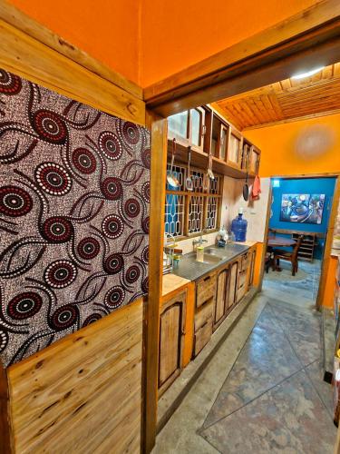 a kitchen with a wall with a design on it at Mazzola Safari House & Backpacking in Arusha