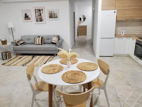 einen weißen Tisch und Stühle im Wohnzimmer in der Unterkunft VINNA Просторі апартаменти в новобудові. in Ternopil