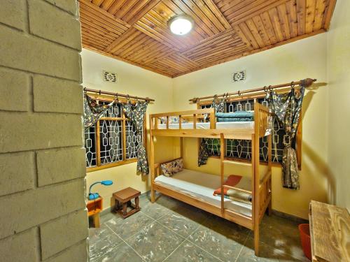 a room with two bunk beds and a brick wall at Mazzola Safari House & Backpacking in Arusha