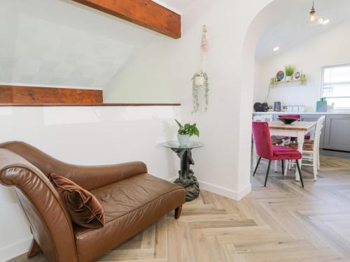 a living room with a leather couch and a table at Minerva in Holyhead