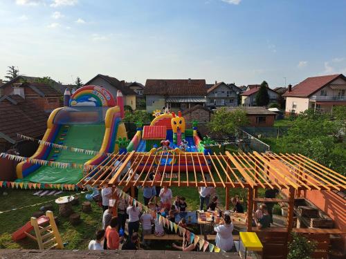 a group of people at an amusement park with a playground at Rooms Baranjska Oaza in Bilje