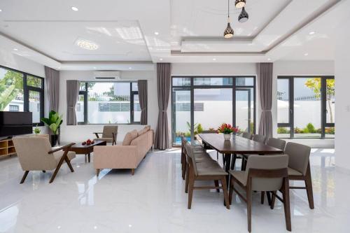 uma sala de jantar e sala de estar com mesa e cadeiras em Palm Villa 10 Near Beach em Vung Tau