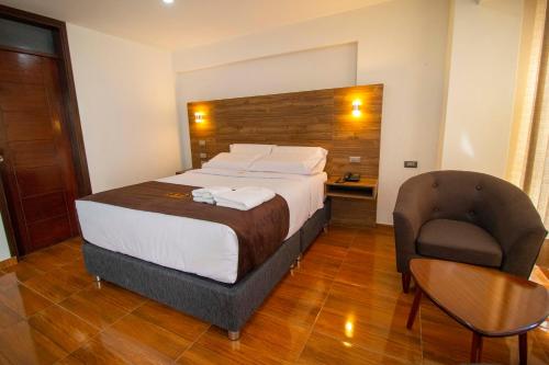 a hotel room with a bed and a chair at Hotel Cumbre Real Airport - Arequipa in Arequipa