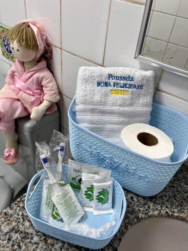 a doll sitting on a toilet in a bathroom at Pousada Dona Felicidade Carneiros in Tamandaré