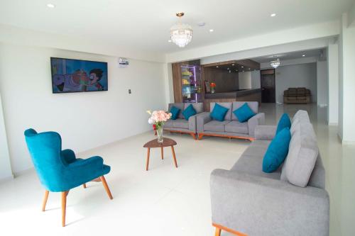 sala de estar con sofá y silla azul en Hotel Cumbre Real Airport - Arequipa, en Arequipa
