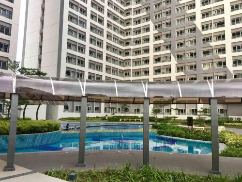 una piscina frente a un gran edificio en Budget Grace Residences en Manila