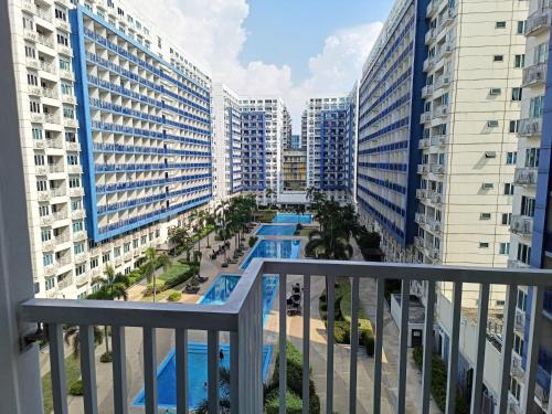 a balcony with a view of a pool and buildings at Premiere Haven MOA Staycation in Manila