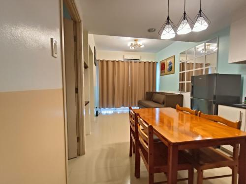 a dining room and kitchen with a wooden table and chairs at Premiere Haven MOA Staycation in Manila
