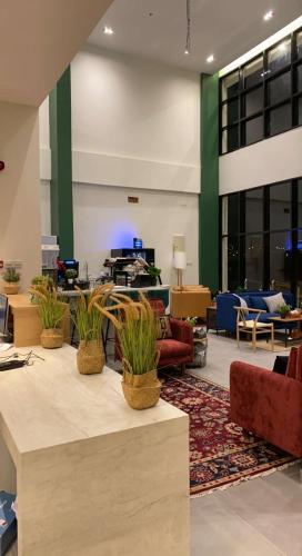 a lobby with three potted plants on a table at ريف سويت للأجنحة الفندقية in Abha