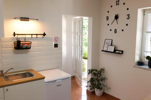 una cocina con fregadero y un reloj en la pared en Wilma, en Čavle