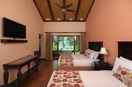 a hotel room with two beds and a flat screen tv at Hotel Boutique La Casona del Cafetal in Cachí
