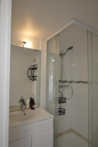 une salle de bain blanche avec une douche et un lavabo dans l'établissement Studio Naturiste ALBATROS Port Soleil 544, au Cap d'Agde