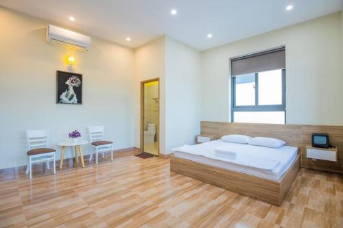 ein Schlafzimmer mit einem Bett und einem Tisch und Stühlen in der Unterkunft Palm Villa 27 - 50M To The Sea in Vũng Tàu