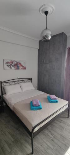 a bedroom with a bed with two towels on it at Victoria Loutraki Лутраки apartment in Loutraki