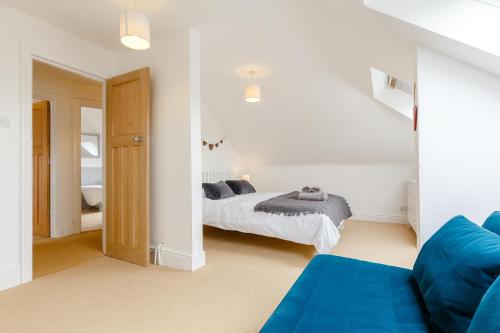 a bedroom with a bed and a blue couch at Wisteria in St Austell