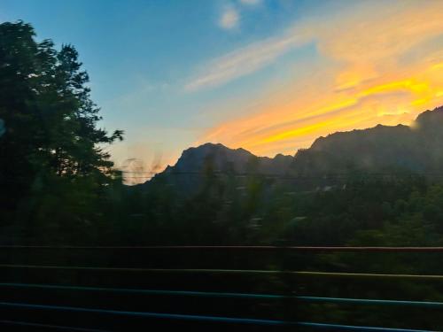 a sunset view from a train window with mountains at Zhangjiajie National Park Nvue Resorts in Zhangjiajie