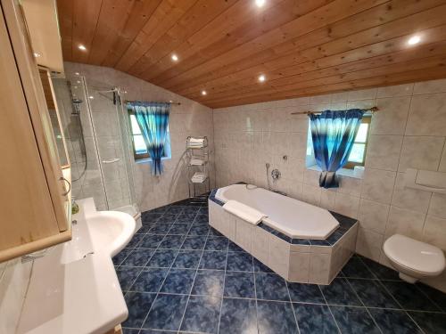 a bathroom with a tub and a toilet and a sink at Lauchlehen in Bischofswiesen