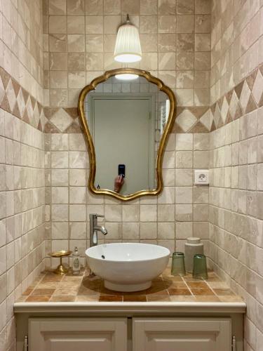 une salle de bain avec un lavabo et un miroir dans l'établissement Les Aurochs, à Grimaud