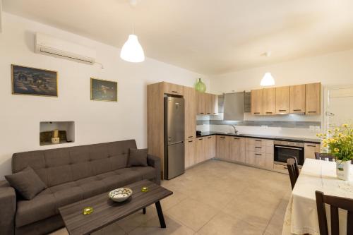 a kitchen and living room with a couch and a table at Peris Rooms in Sifnos