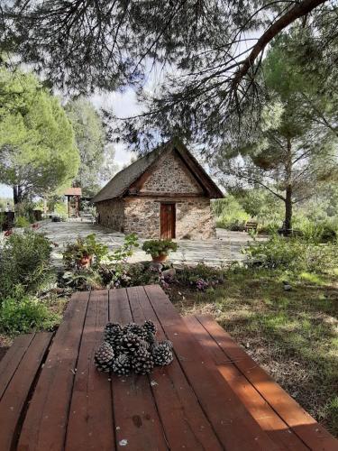a wooden table in front of a stone building at THE ROCK HOUSE - Beautiful countryside with mandarins oranges and olive trees,. Near Limassol at Eptagonia village. in Ephtagonia