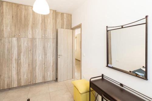 a living room with a mirror and a yellow chair at Peris Rooms in Sifnos