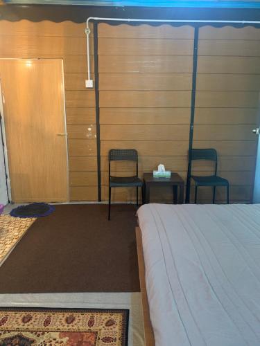 a room with two chairs and a bed and a table at SABAYA HOMESTAY in Balik Pulau