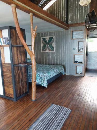- une chambre avec un lit et un arbre dans l'établissement Faré Mahi Mahi, à Uturoa