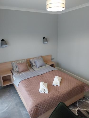 a bedroom with a bed with two towels on it at VILLA EDEN USTKA wypoczynek dla dorosłych in Ustka