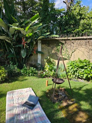 a laptop on a blanket in a yard with a chair at Mazzola Safari House & Backpacking in Arusha