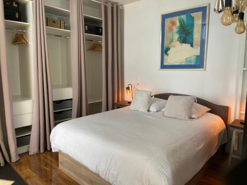 een slaapkamer met een groot wit bed en gordijnen bij Ô Phare du Cros in Cagnes-sur-Mer