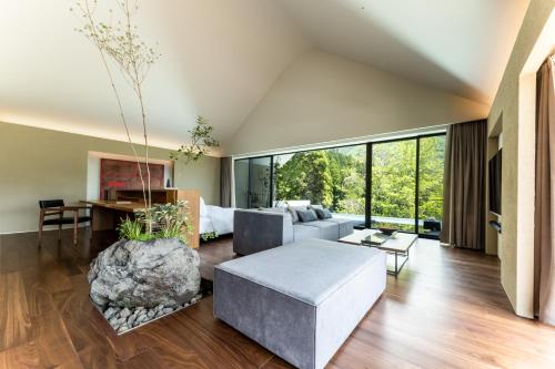 a living room with a couch and a large window at ENOWA in Yufuin