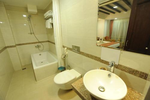a white bathroom with a sink and a toilet at Apsara Boutique Hotel in Kathmandu
