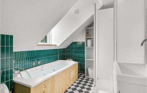 y baño con azulejos verdes y bañera. en Gorgeous Apartment In Hjer With Kitchen en Højer