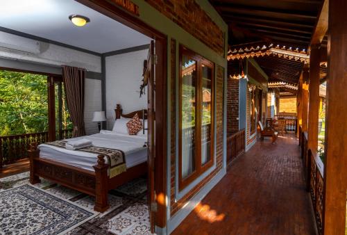 una camera con un letto su una veranda di Balkondes Majaksingi Jasamarga a Borobudur