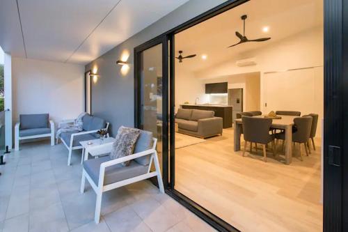 a living room with chairs and a dining room at Sojourn on Fearn - Margaret River in Margaret River Town