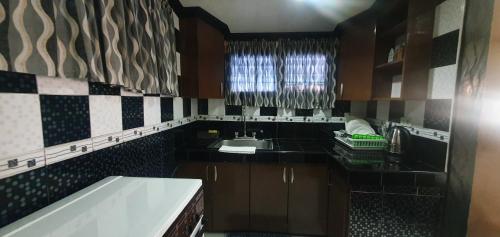 una pequeña cocina con fregadero y ventana en JCGA Apartments (Angelo's Burnham) en Baguio