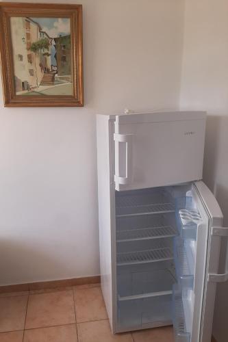 an empty refrigerator with its door open in a room at Glaros Studios in Loutra Edipsou