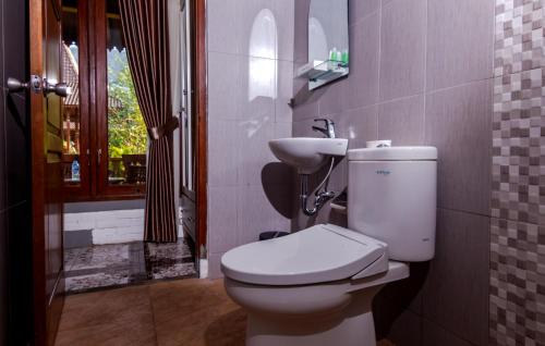 La salle de bains est pourvue de toilettes et d'un lavabo. dans l'établissement Balkondes Majaksingi Jasamarga, à Borobudur