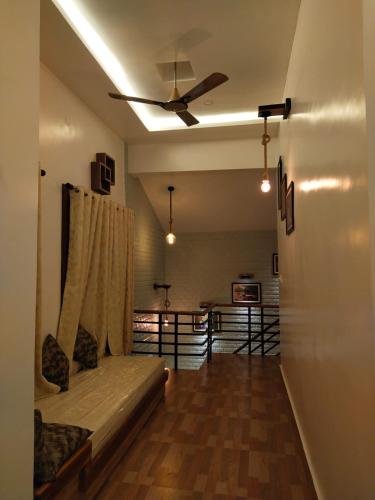 a living room with a couch and a ceiling fan at CHARULATA RESIDENCY in Bolpur