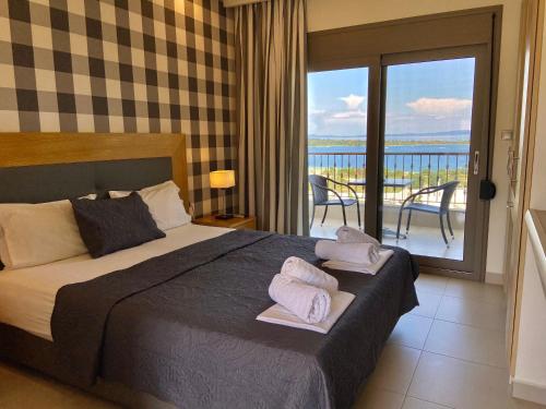 a bedroom with a bed and a balcony with a view at Panorama Dream Studios B in Vourvourou