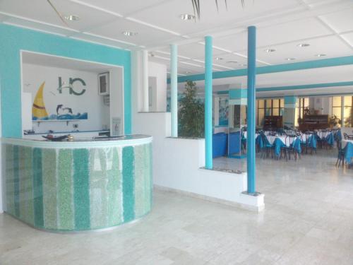 a large room with blue columns and tables and chairs at Hotel La Carruba in Cetraro